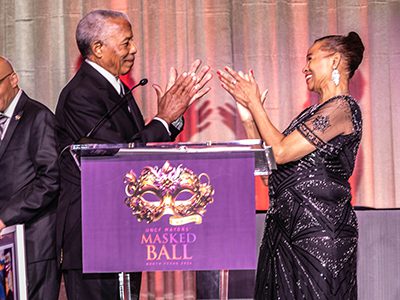 Two people clapping behind a podium