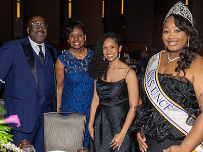 Three masked ball attendees and Miss UNCF