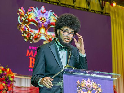 A speaker addressing the room at the 10th annual mayor's masked ball