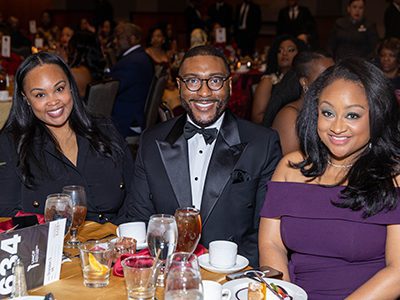Three patrons at a table at the mayor's masked ball