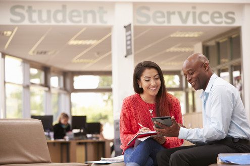 College Student Having Meeting With Tutor To Discuss Work