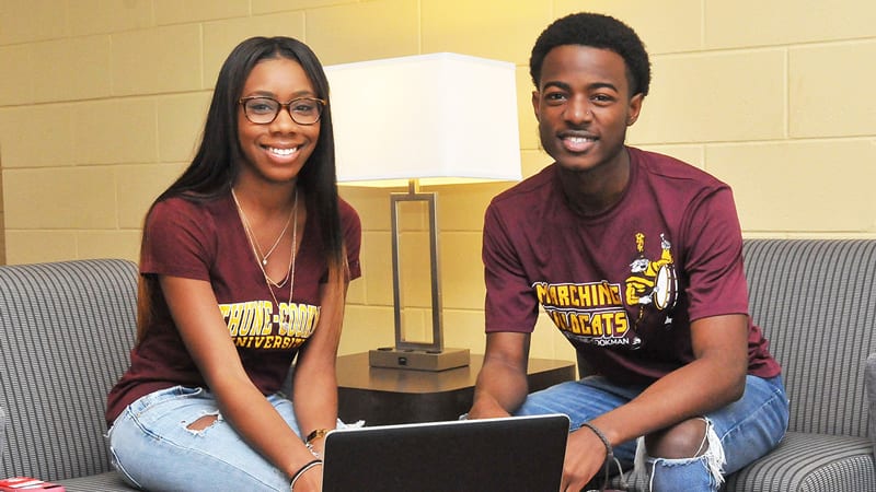 Male and Female Bethune-Cookman Students smiling with laptop