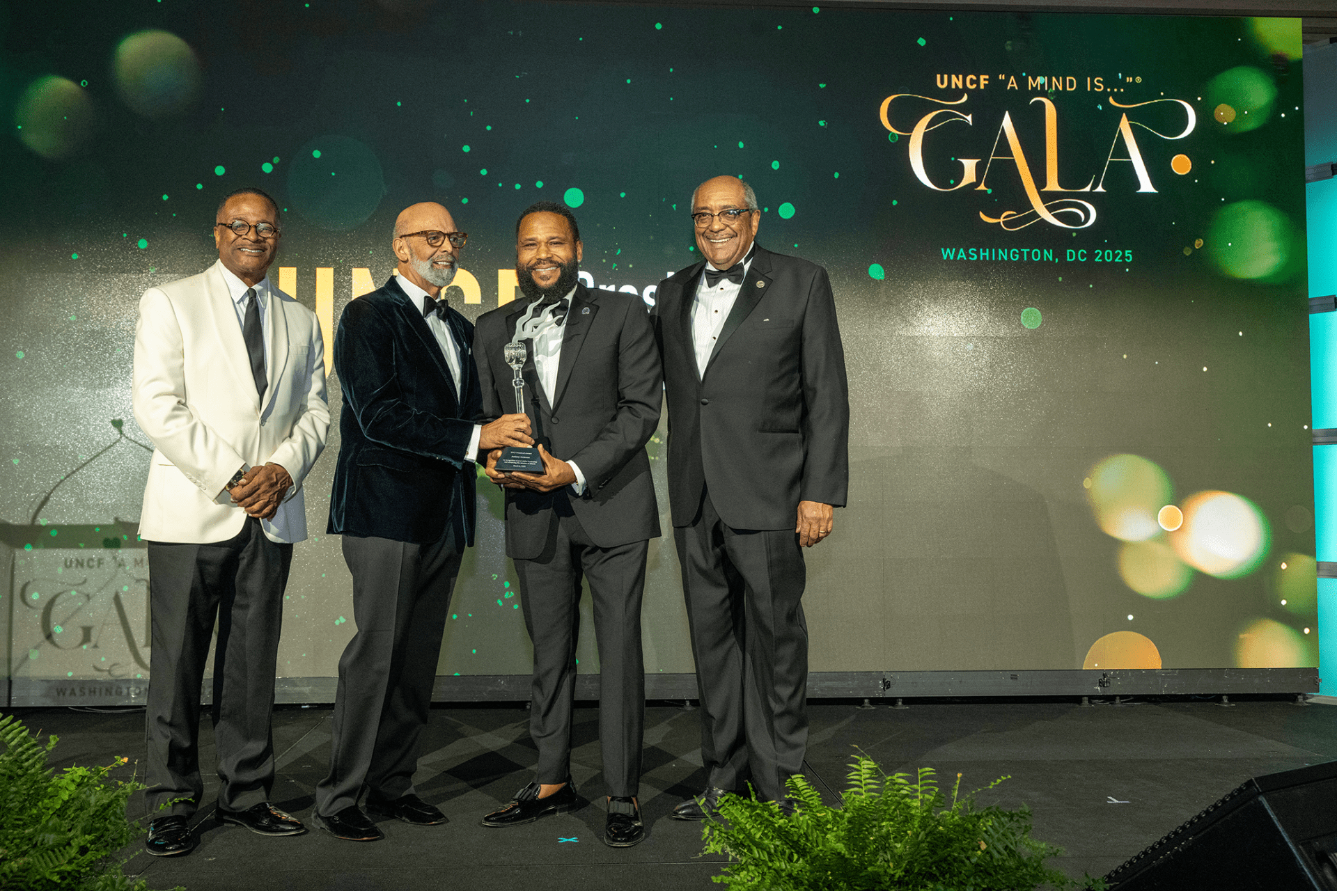 UNCF President and CEO Dr. Michael L. Lomax presents the President's Award to Anthony Anderson, actor, comedian, TV host and longtime friend of UNCF, at the 2025 National "A Mind Is..." Gala. Joining Dr. Lomax are  (l) Clark Atlanta University President Dr. George T. French. Jr., and (r) UNCF Board Chair Milton H. Jones, Jr.