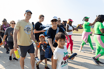 Family stopping to take photo as they walk with crowd