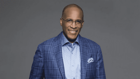 Dr. Walter Kimbrough, executive vice president, UNCF, in a blue suit and light blue shirt stands in front of a gray background.