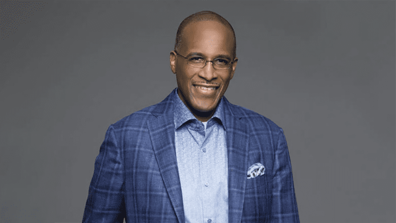 Dr. Walter Kimbrough, executive vice president, UNCF, in a blue suit and light blue shirt stands in front of a gray background.