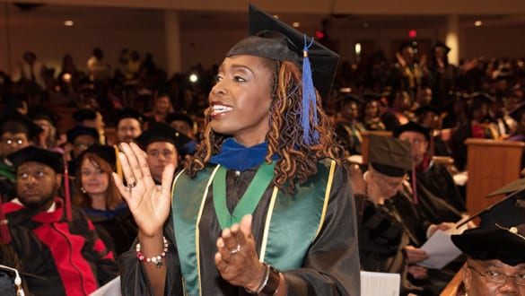 Female professor at Edward Waters College graduation ceremony wearing her cap and gown