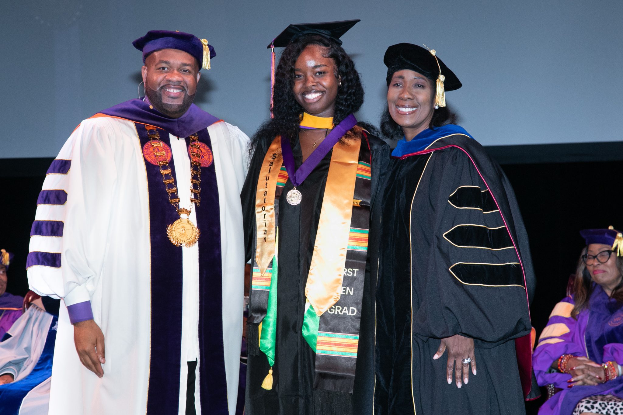 Three people in graduation attire