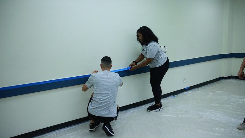 two Enterprise team members preparing to paint a room