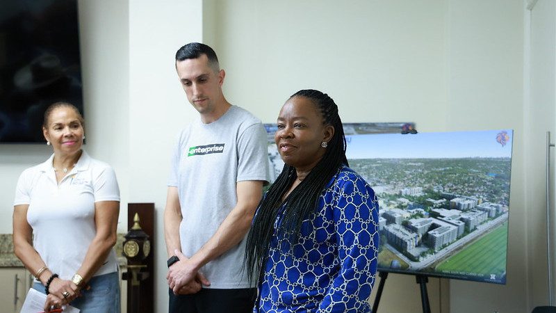 Enterprise team member with FMU official standing in dorm room
