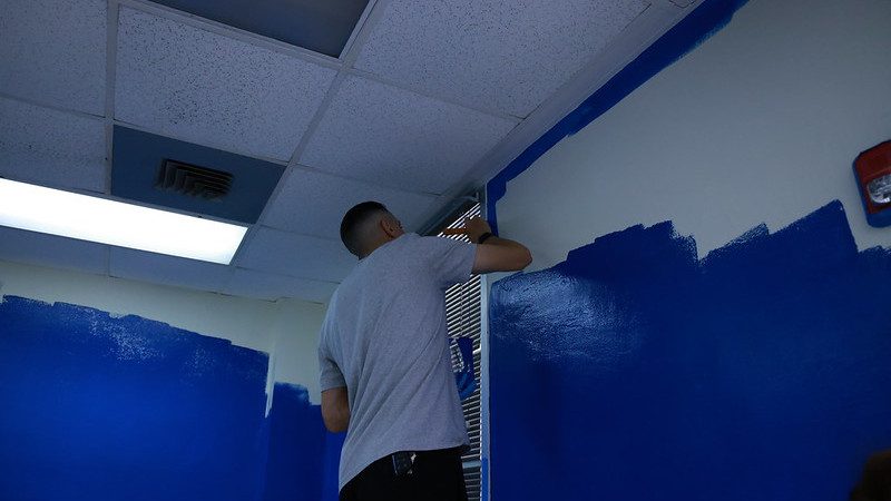 Enterprise team member painting a wall