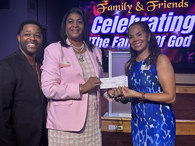 Three people presenting a donation check