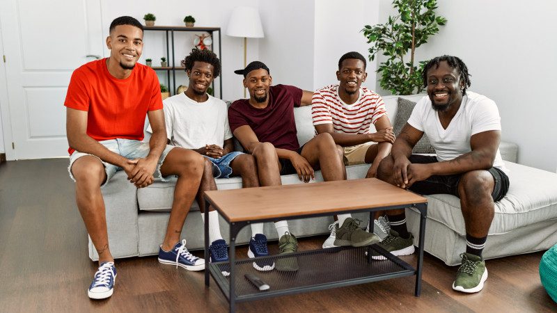 Group of african american people smiling happy sitting on the sofa at home.