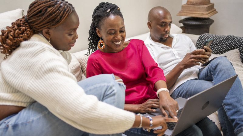 Family on couch looking at laptop