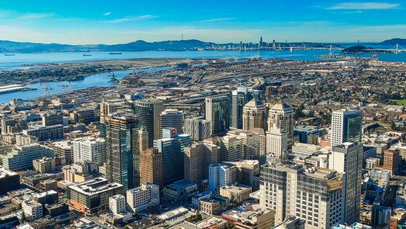 The City of Oakland CA with San Francisco in the background sits on the edge of the San Francisco Bay..