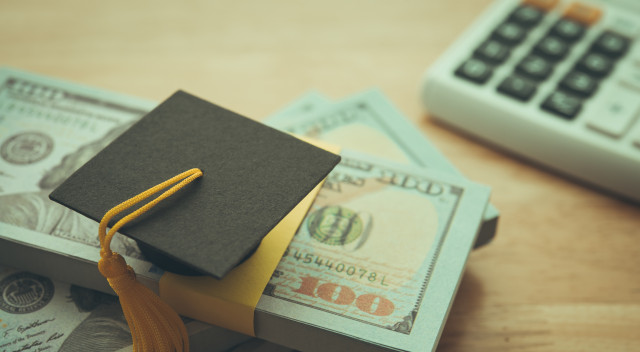 Graduation cap university on stack US dollar banknote,