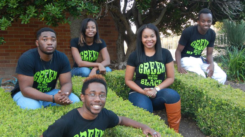Exterior Shot of Huston-Tillotson University students wearing shirts that say "Green is the new black"