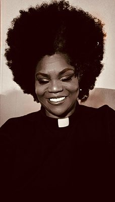 Beloved Dillard, wearing a clerical collar, is an ordained licensed minister. She received a master’s of divinity at Interdenominational Theological Center in Atlanta, GA, and is in the second year of her doctoral of ministry degree.