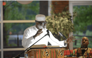 A person speaking at a lit podium