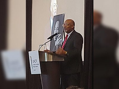 Glen Ivey speaking at podium