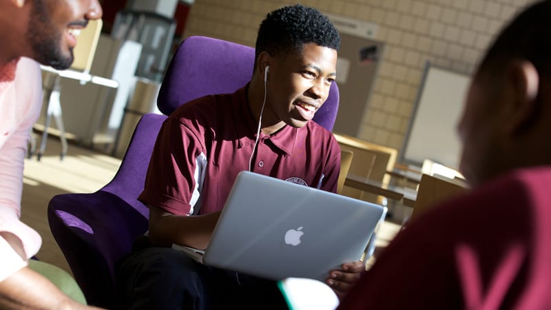 3 male students studying and talking with laptop at Morehouse College