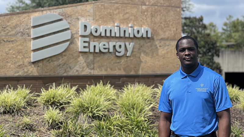 Jahavheed George standing beside a facade with the Dominion Energy logo