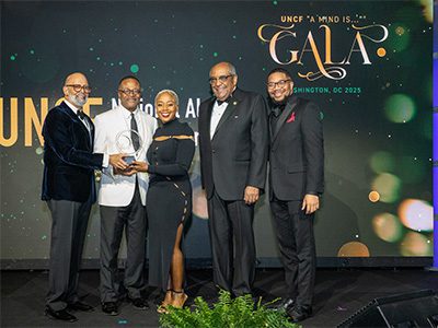 group of people on stage person in the middle is receiving an award