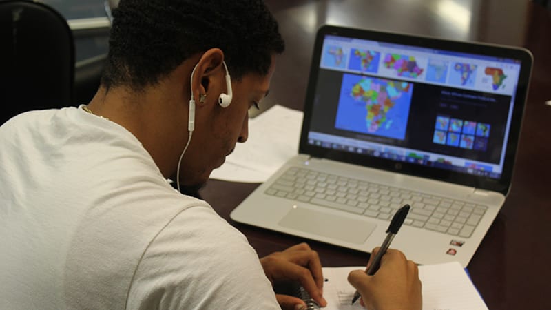 Student studying Africa's geography on a laptop