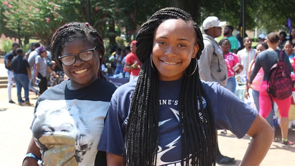 Pair of female students smiling at pep rally