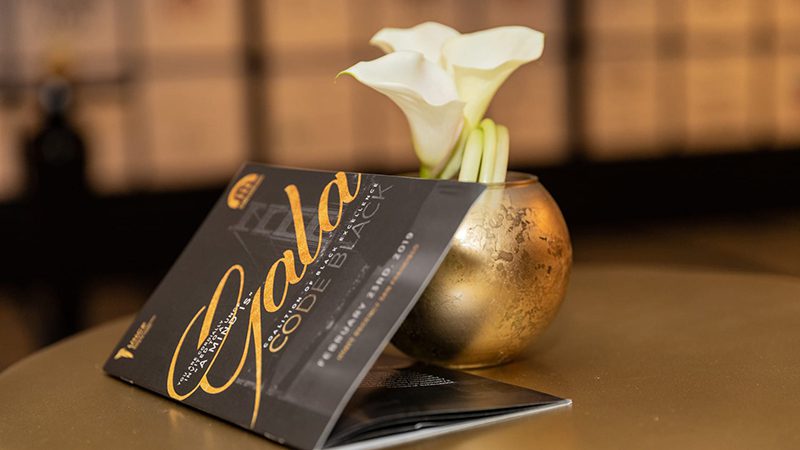 UNCF Gala booklet on a table in front of a flower display