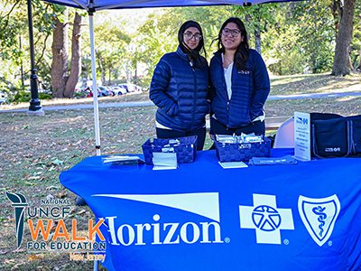 two event vendors standing their table