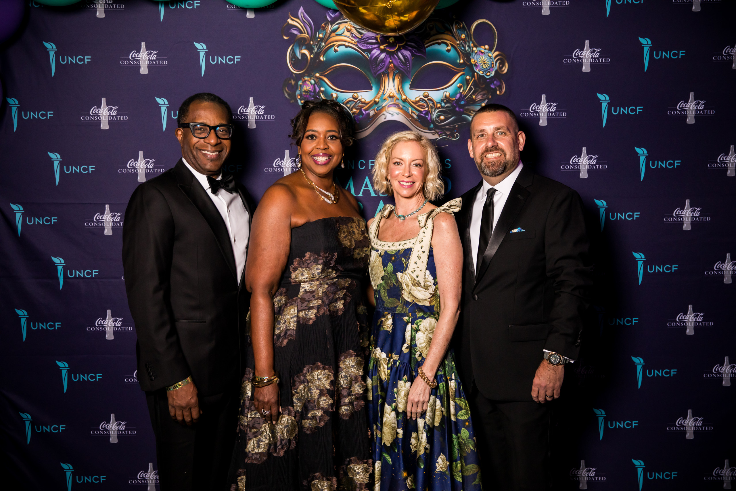 group of event attendees in front of step n repeat