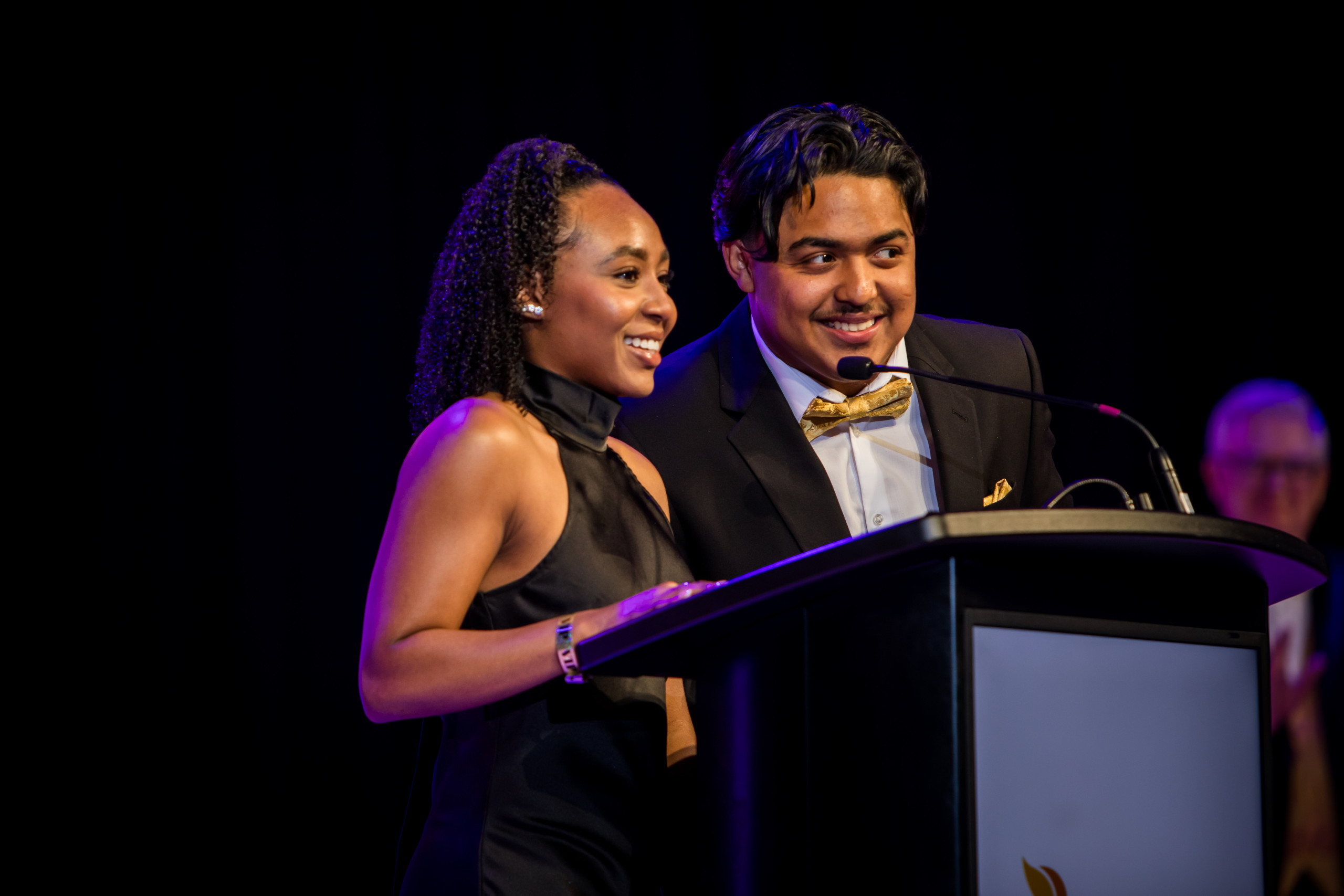 two students speaking at podium