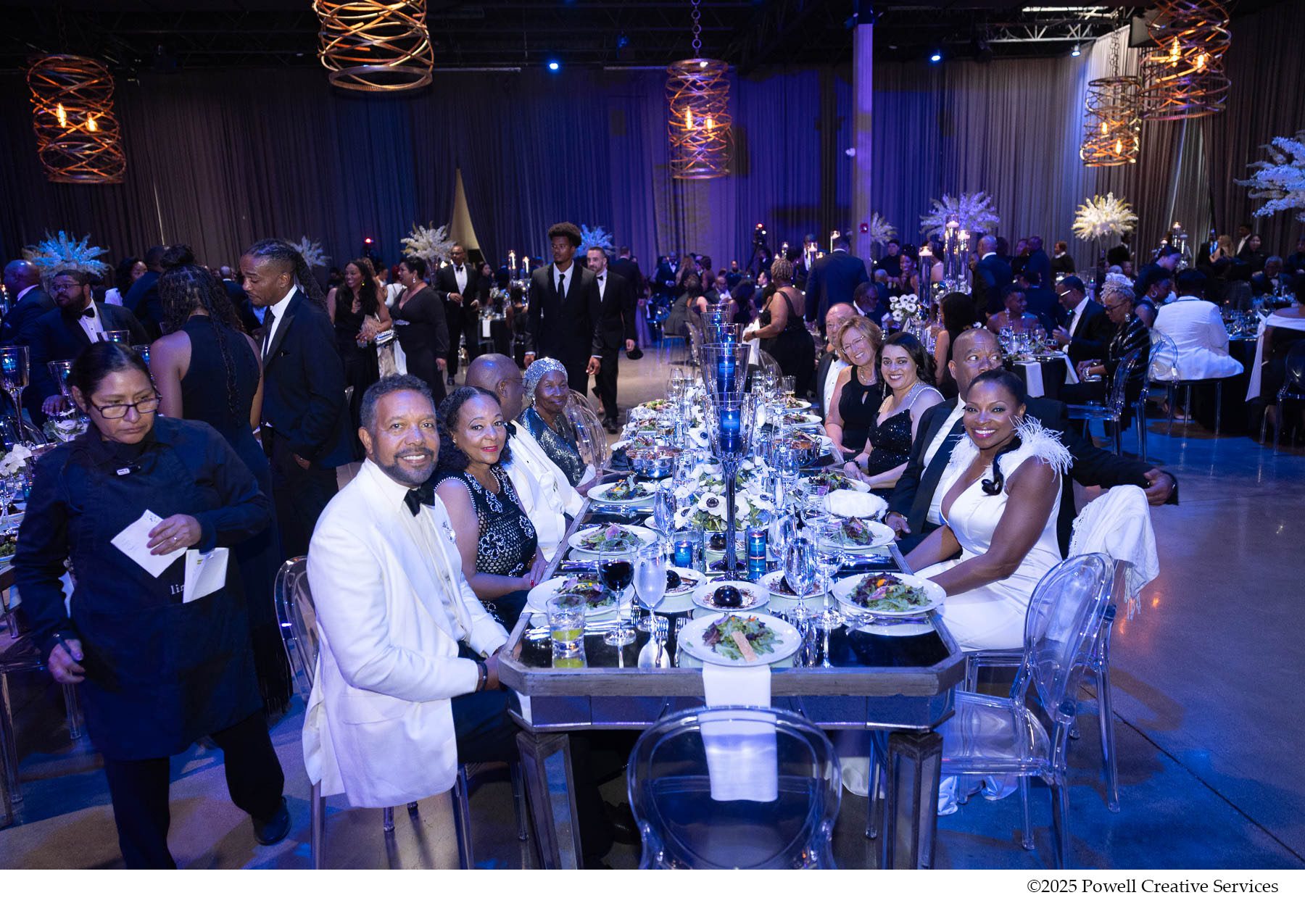 Shot of crowd, the people in the middle are seated and smiling at the camera