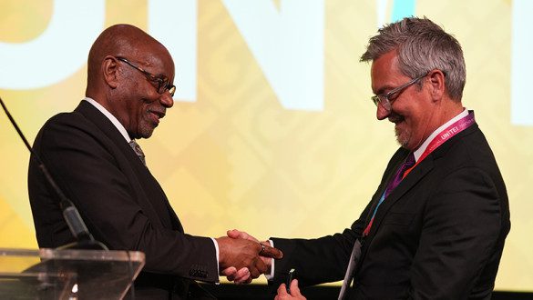 two people shaking hands onstage at UNITE 2026
