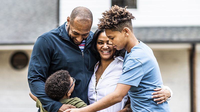 Portrait of family in front of residential home