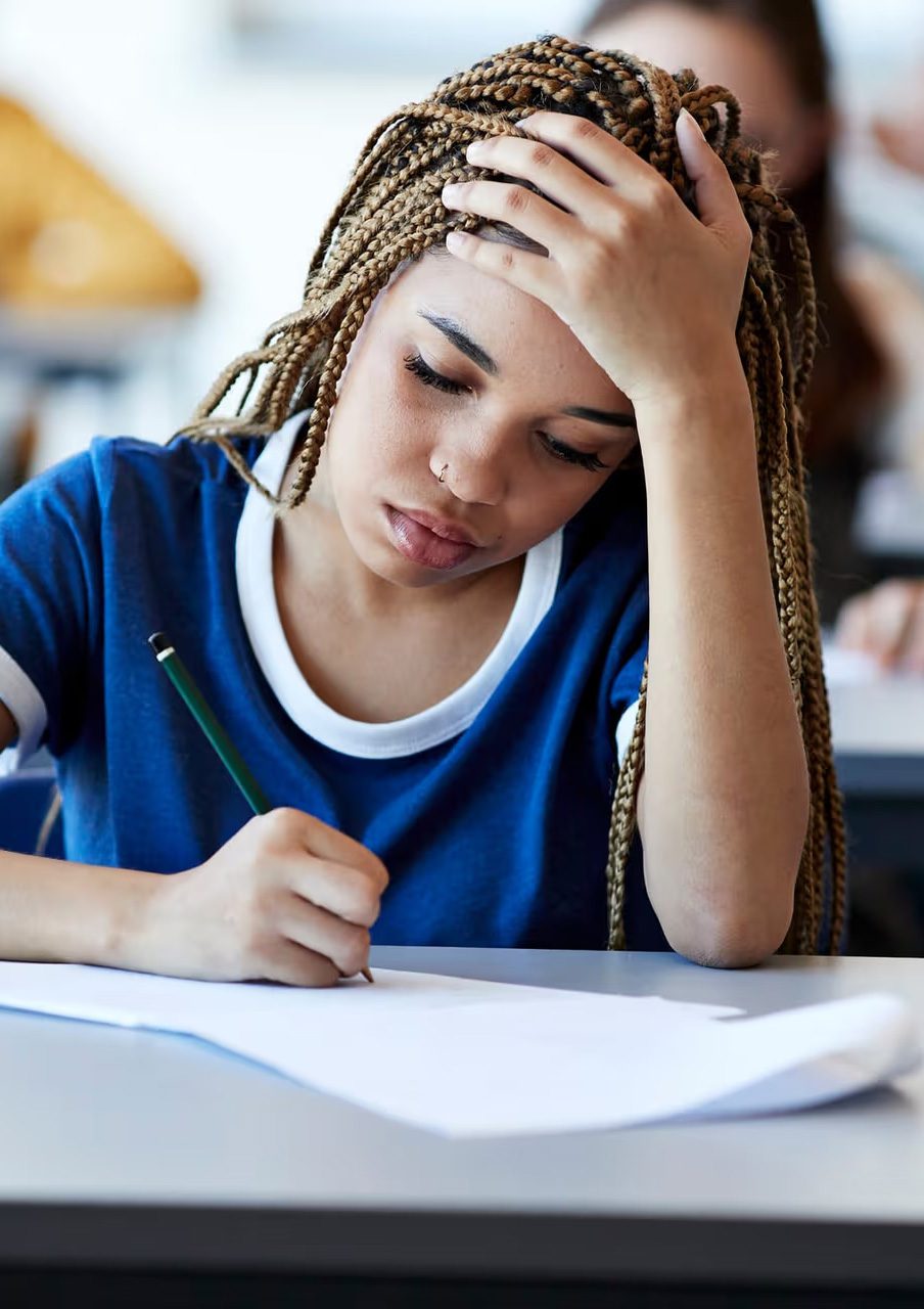 Student writing at desk