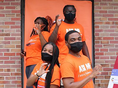 Claflin students pose with their hands in a C shape