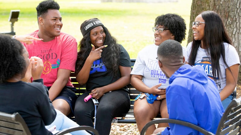 6 Dillard University students talking together outside on campus