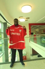 Lawrence Nalls, III holds up a Coca-Cola UNITED T-shirt. Photos from Lawrence Nalls, III.