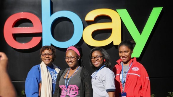 4 female college students standing under an eBay sign