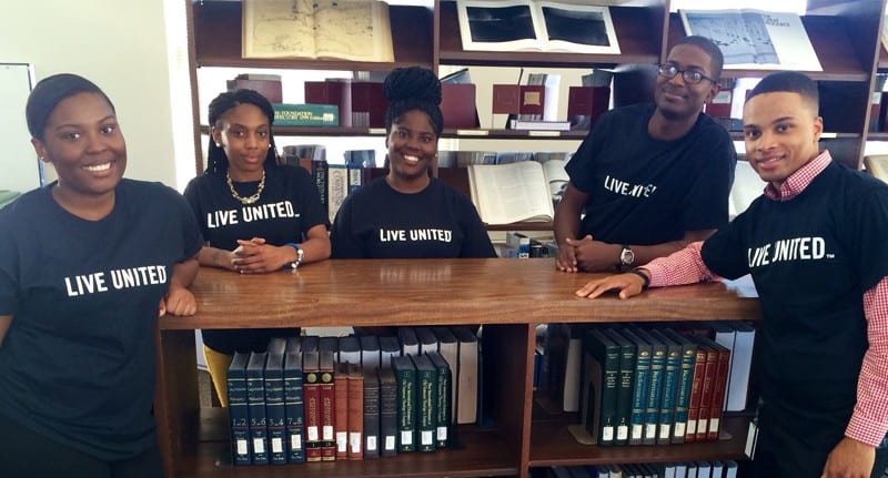 Group shot of 5 Allen University students in library wearing Live United t-shirts