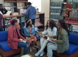 Four students at Allen University talking in library