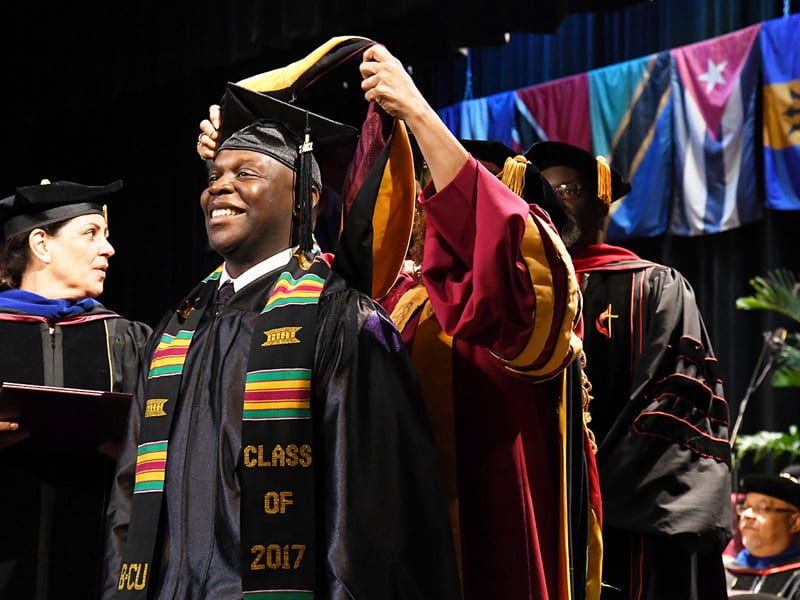 Male student receiving honors during graduation ceremony at Bethune Cookman University