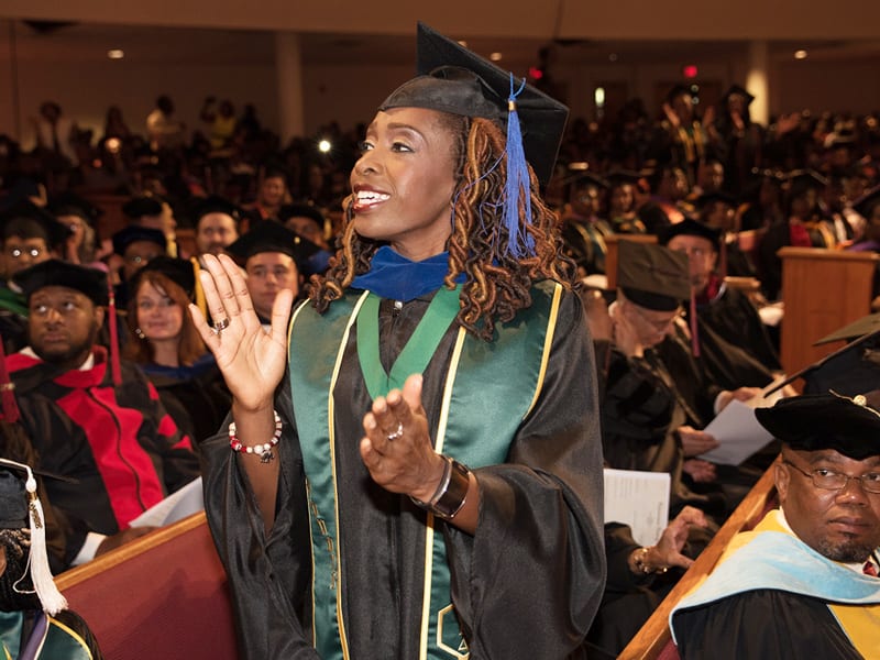 Female professor at Edward Waters College graduation ceremony wearing her cap and gown