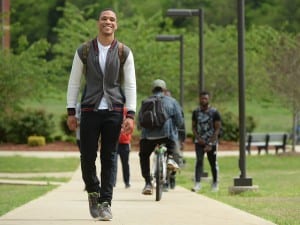 Male Oakwood University students outside on campus walking and biking