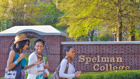 Sign at Spelman College with students walking nearby