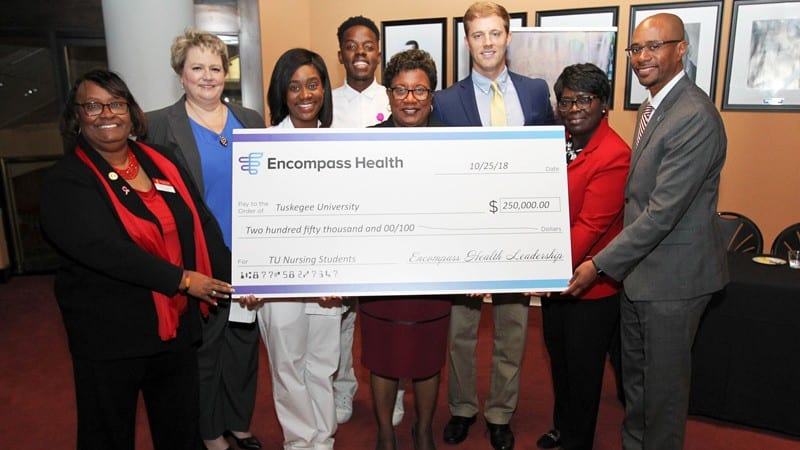 Group shot presentation of check form Encompass Health to Tuskegee University
