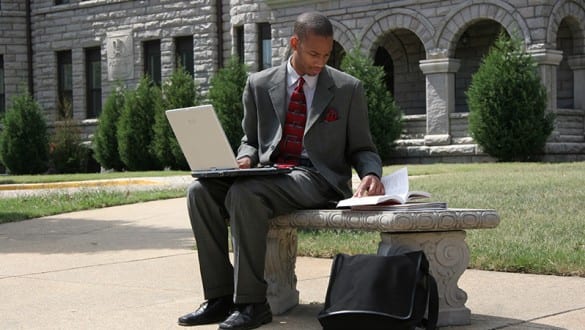 Male student with laptop working at Virginia Union University outside