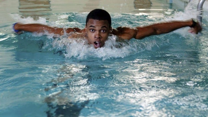 Male Voorhees College student swimming in lap pool